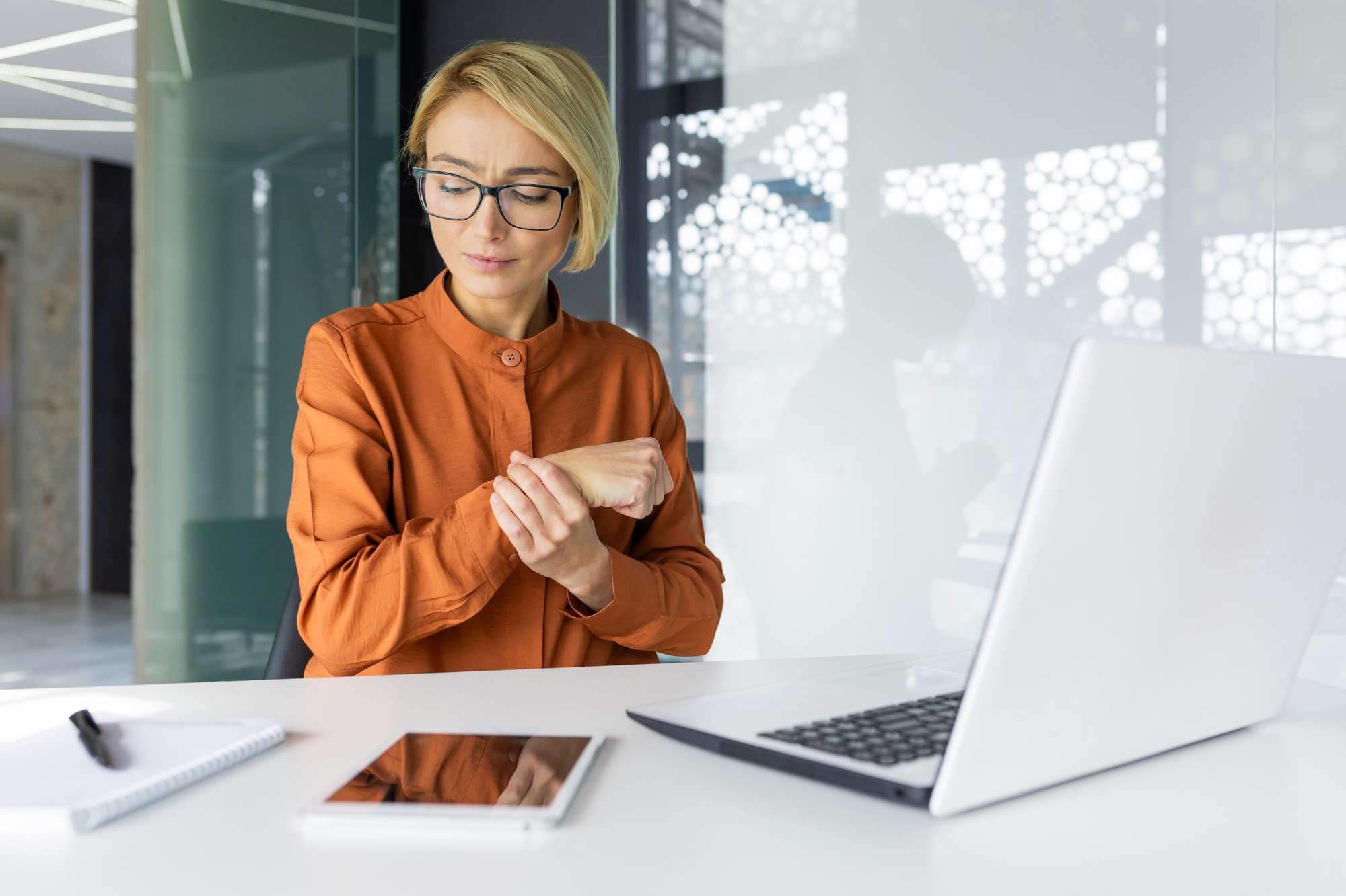 Office worker woman has severe pain in hand joints, long sitting work in business woman at